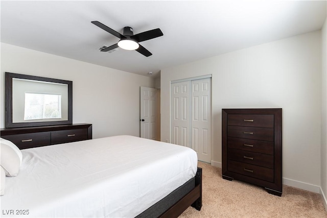 bedroom featuring ceiling fan, light colored carpet, visible vents, baseboards, and a closet