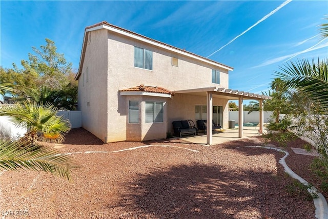 back of house featuring a tile roof, a patio, stucco siding, a pergola, and a fenced backyard