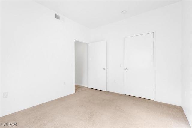 unfurnished bedroom with visible vents and light colored carpet