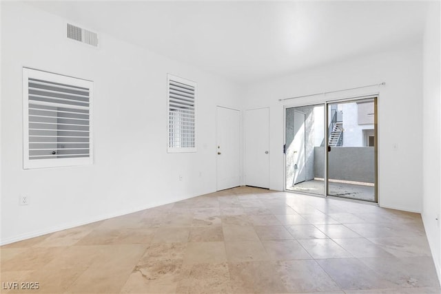 unfurnished room featuring tile patterned floors, baseboards, and visible vents