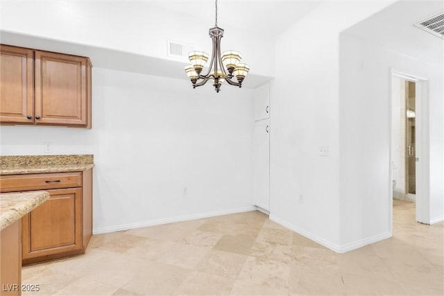 unfurnished dining area with a chandelier, visible vents, and baseboards