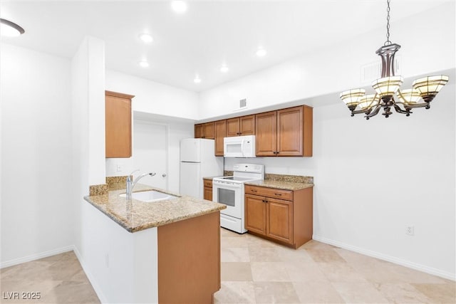 kitchen featuring light stone countertops, a peninsula, brown cabinetry, white appliances, and a sink