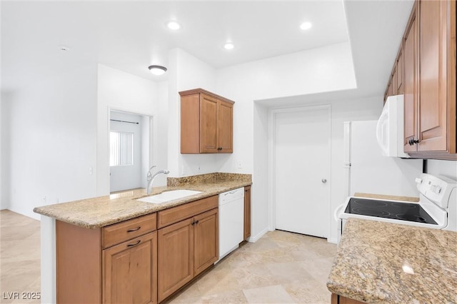 kitchen with white appliances, light stone counters, recessed lighting, a sink, and brown cabinets