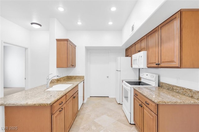 kitchen with light stone countertops, recessed lighting, a peninsula, white appliances, and a sink