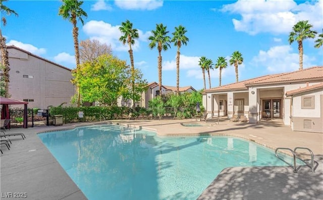 community pool featuring a patio and fence