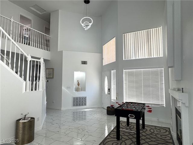 entryway with marble finish floor, baseboards, stairway, and visible vents