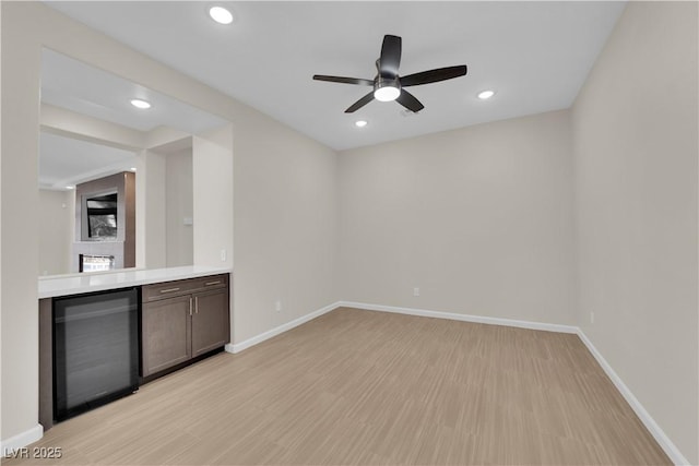 interior space featuring beverage cooler, recessed lighting, light wood-type flooring, and baseboards