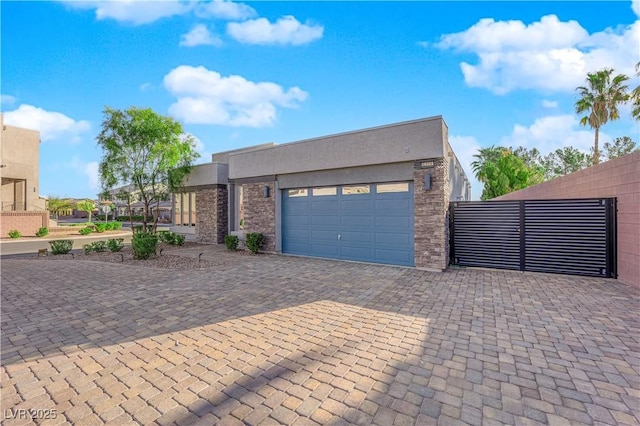 view of front of house with an attached garage, fence, stone siding, decorative driveway, and stucco siding