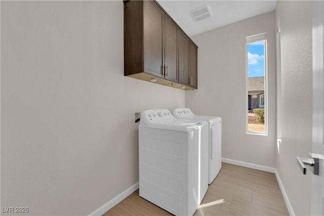 laundry room with cabinet space, baseboards, visible vents, and washing machine and clothes dryer