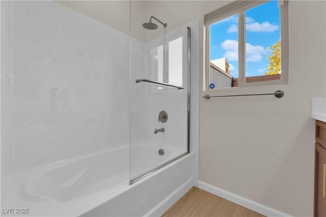 bathroom with  shower combination, vanity, baseboards, and wood finished floors