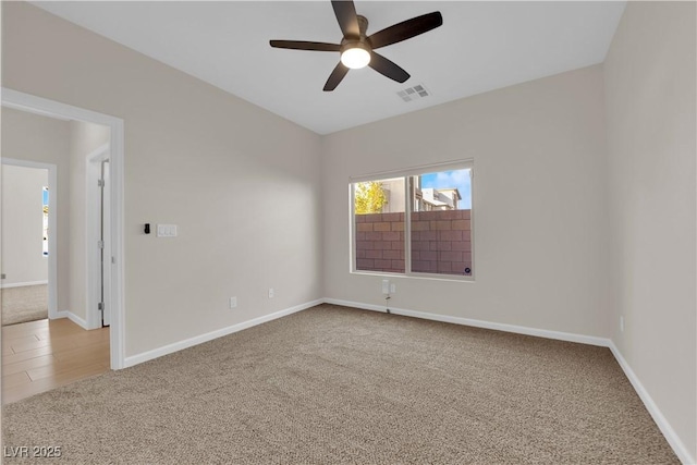 carpeted empty room featuring visible vents, ceiling fan, and baseboards