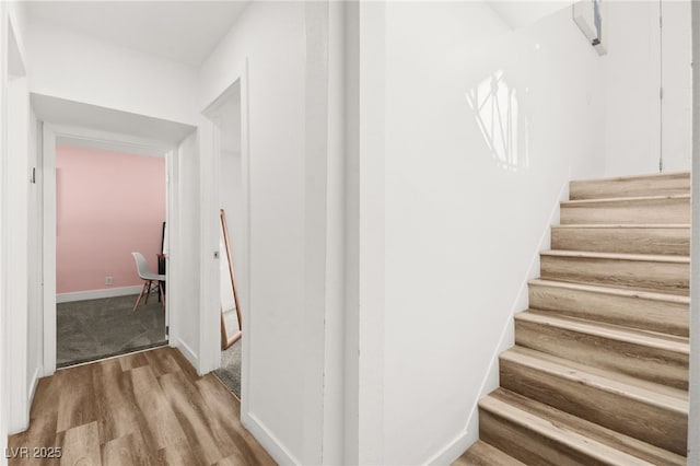 stairway featuring baseboards and wood finished floors