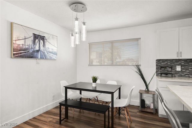 dining area with a textured ceiling, dark wood finished floors, and baseboards