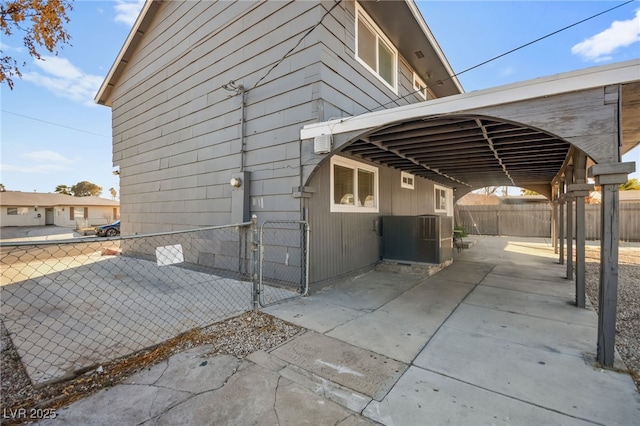 view of side of home featuring cooling unit, a gate, and fence