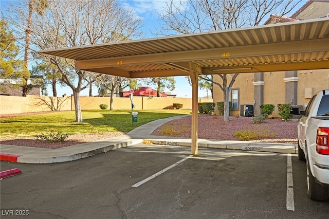 covered parking lot featuring fence