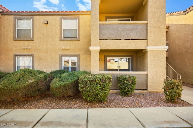 view of front of home featuring a balcony and stucco siding