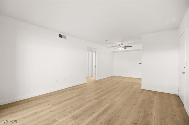 empty room featuring a ceiling fan, light wood-type flooring, visible vents, and baseboards