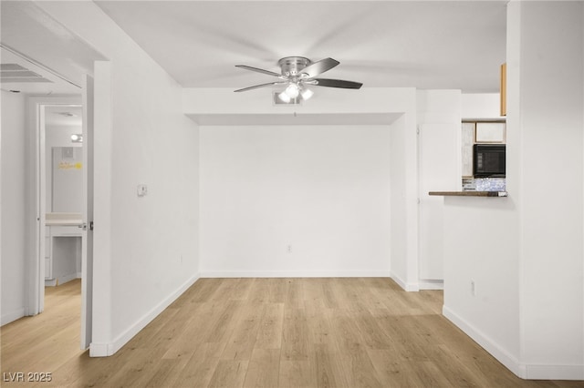 interior space with ceiling fan, wood finished floors, and baseboards