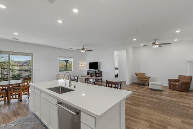 kitchen with light wood-type flooring, open floor plan, a sink, and dishwasher