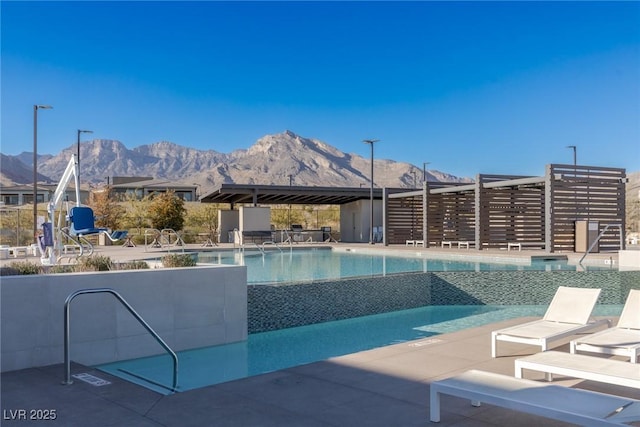 community pool with a patio area and a mountain view