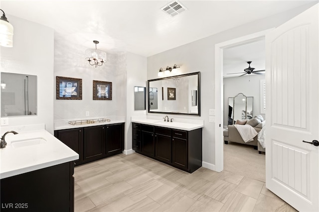 ensuite bathroom featuring two vanities, visible vents, a sink, and ensuite bath