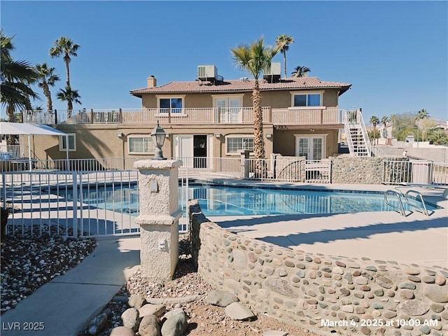 view of swimming pool featuring a fenced in pool, french doors, a patio, central AC unit, and fence