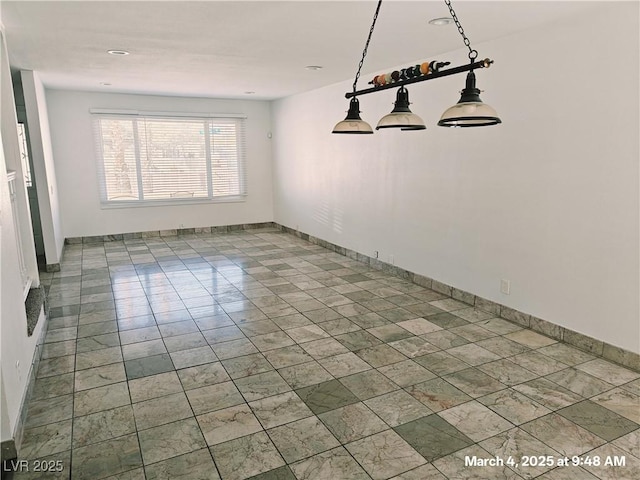 unfurnished dining area with baseboards