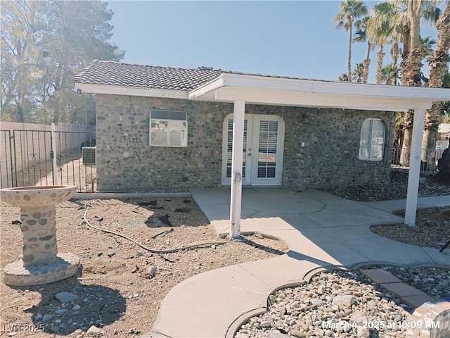 back of house featuring a tiled roof, french doors, a patio, and fence