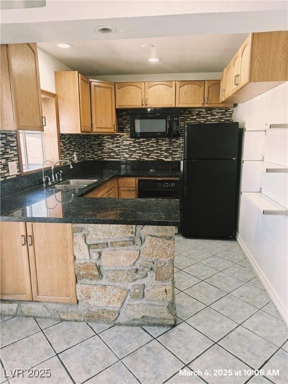 kitchen with light tile patterned floors, a peninsula, a sink, decorative backsplash, and black appliances