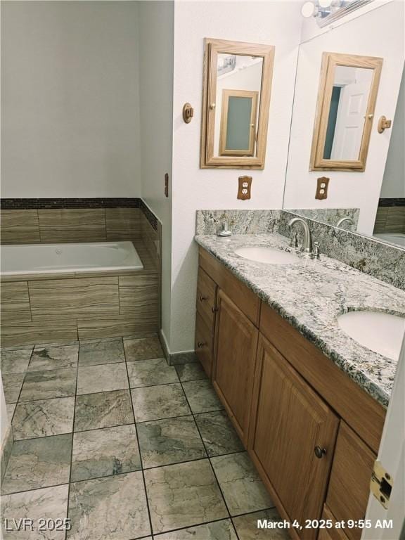 bathroom with double vanity, a tub to relax in, and a sink