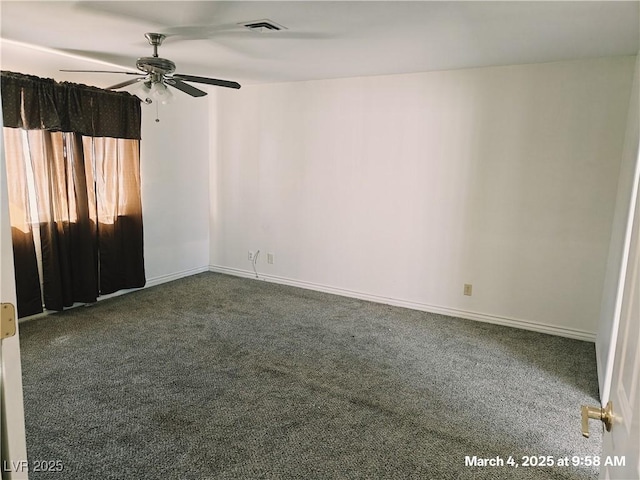 spare room with dark colored carpet, a ceiling fan, visible vents, and baseboards