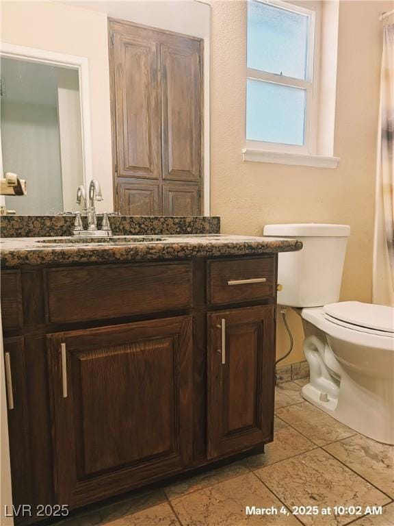 bathroom with toilet, tile patterned floors, and vanity