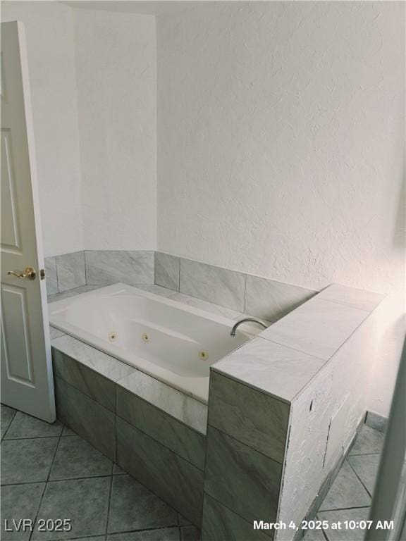 full bathroom with a whirlpool tub, a textured wall, and tile patterned floors