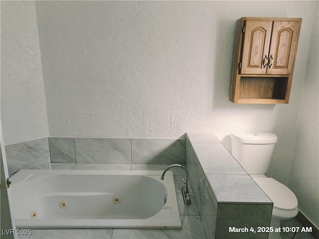 bathroom with a textured wall, toilet, and a tub with jets