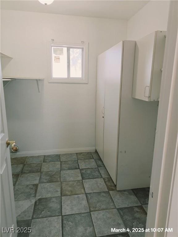 laundry area with baseboards