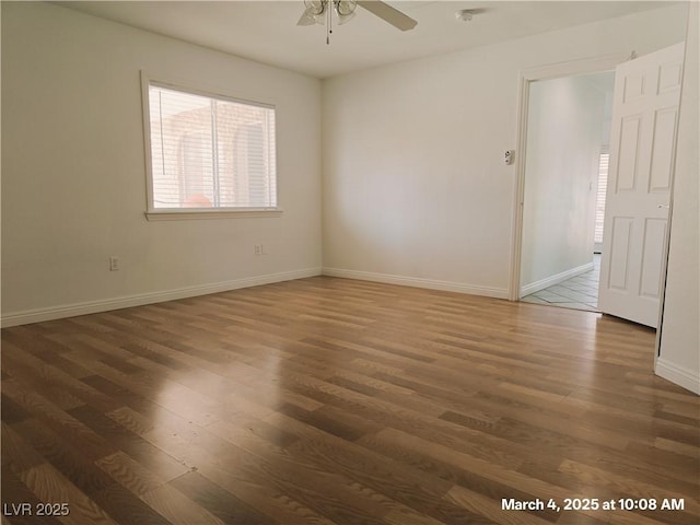 spare room with ceiling fan, wood finished floors, and baseboards