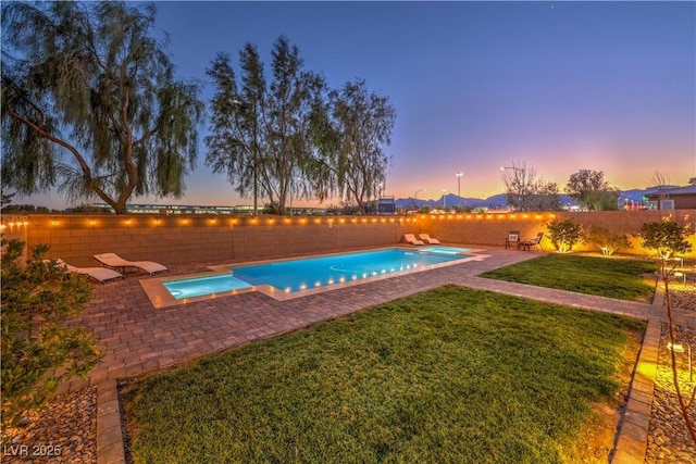 view of pool with a patio, a lawn, a fenced backyard, and a pool with connected hot tub