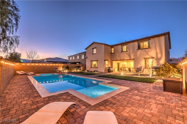 view of pool with a pool with connected hot tub, a fenced backyard, and a patio