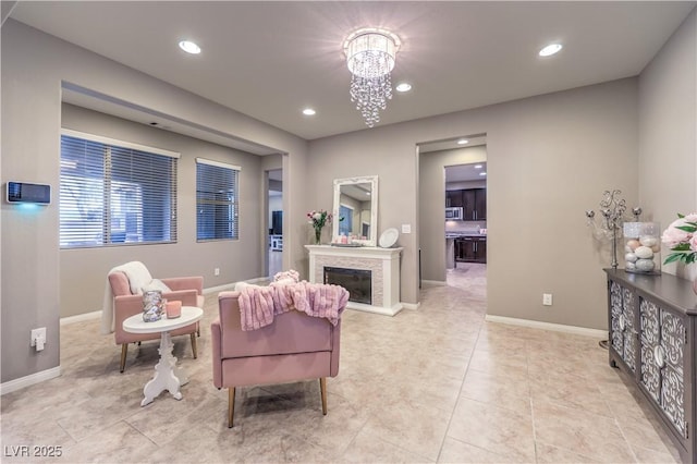 living area featuring a fireplace with raised hearth, light tile patterned floors, a chandelier, recessed lighting, and baseboards