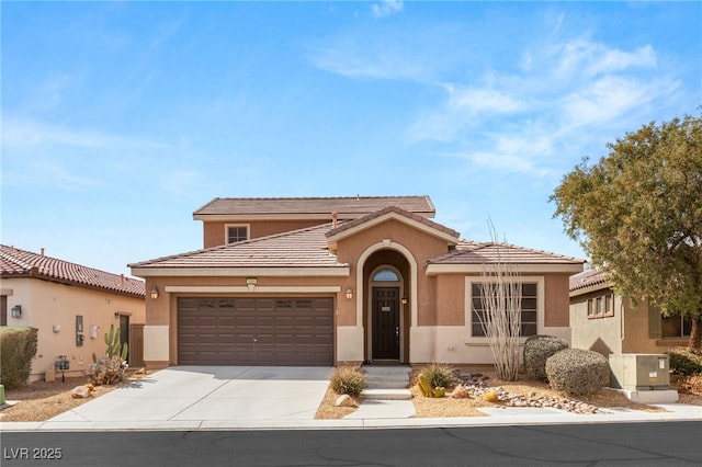 mediterranean / spanish-style home with concrete driveway, central AC unit, an attached garage, and stucco siding