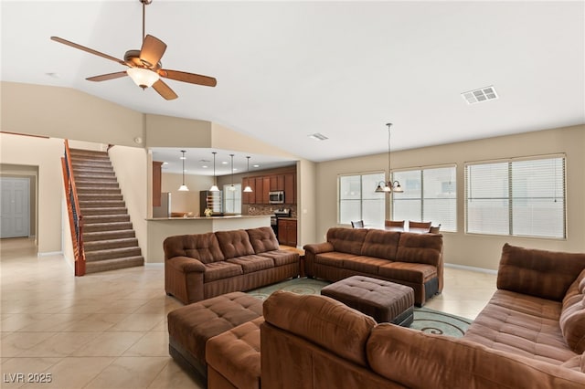 living room featuring light tile patterned floors, stairs, visible vents, and vaulted ceiling