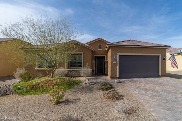 single story home featuring a tiled roof, decorative driveway, an attached garage, and stucco siding