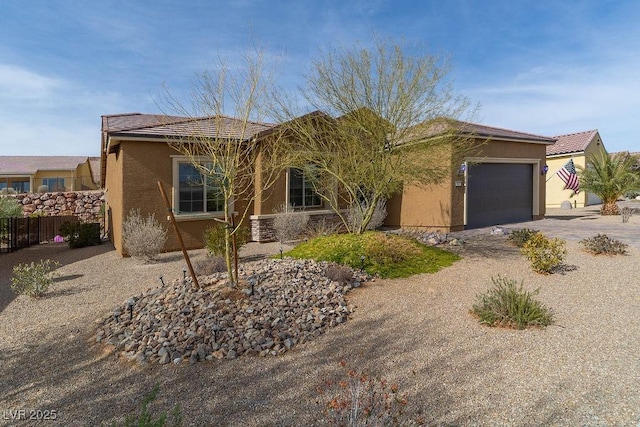 single story home featuring driveway, a tile roof, an attached garage, fence, and stucco siding