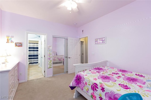 bedroom with ceiling fan, a closet, and light colored carpet