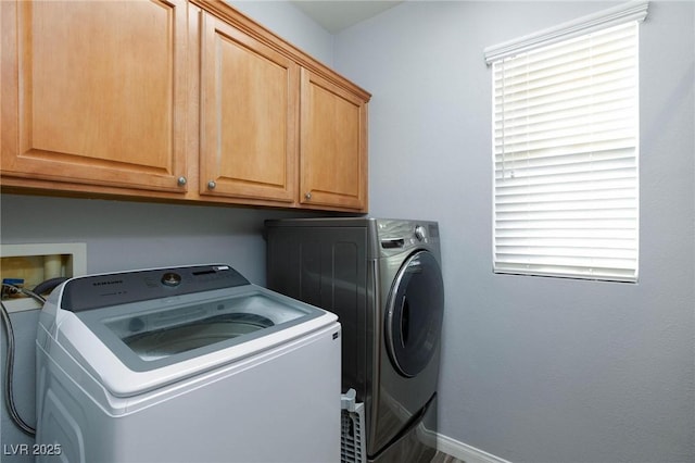 laundry room featuring cabinet space, baseboards, and separate washer and dryer