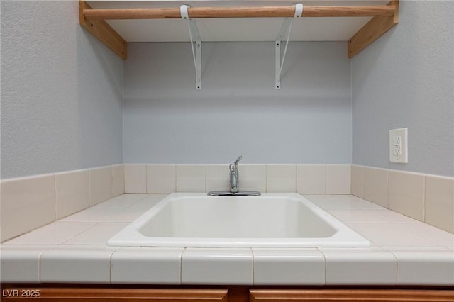 interior space with tile countertops and a sink