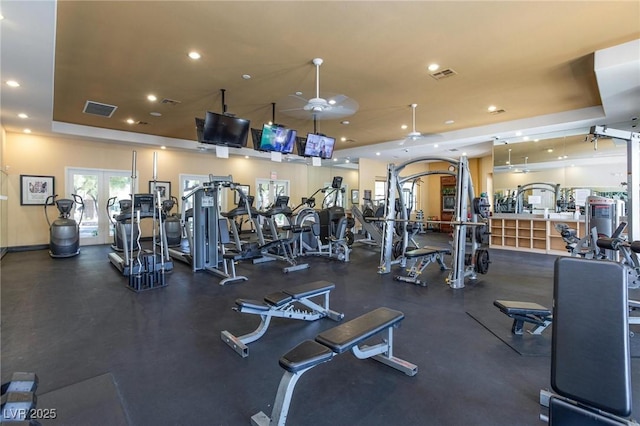 exercise room with recessed lighting, baseboards, visible vents, and a tray ceiling