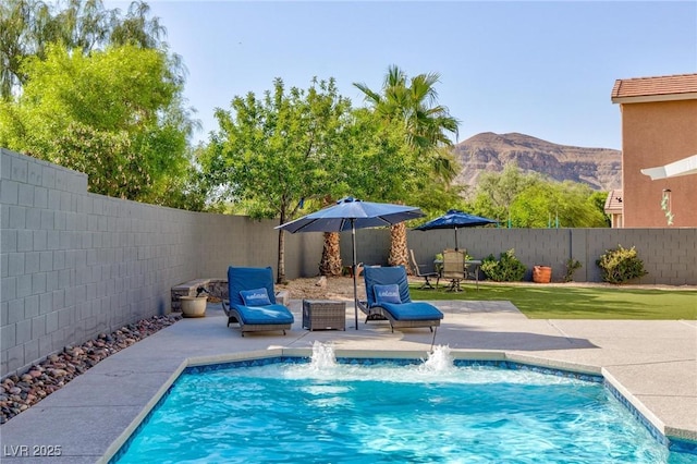 view of swimming pool featuring a patio area, a fenced backyard, a mountain view, and a fenced in pool