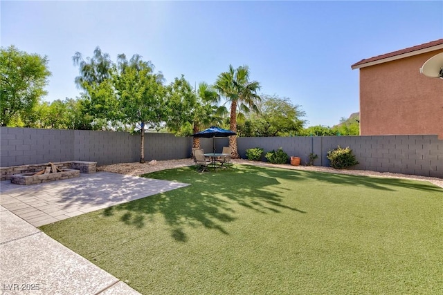 view of yard featuring a patio area, a fenced backyard, and a fire pit