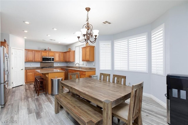 dining room with a notable chandelier, recessed lighting, visible vents, light wood-style floors, and baseboards